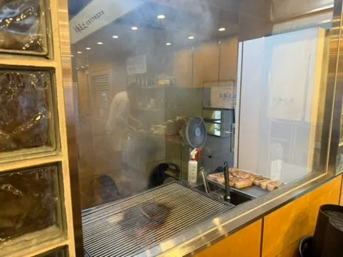 Staff pre-searing meat at the station beside the kitchen