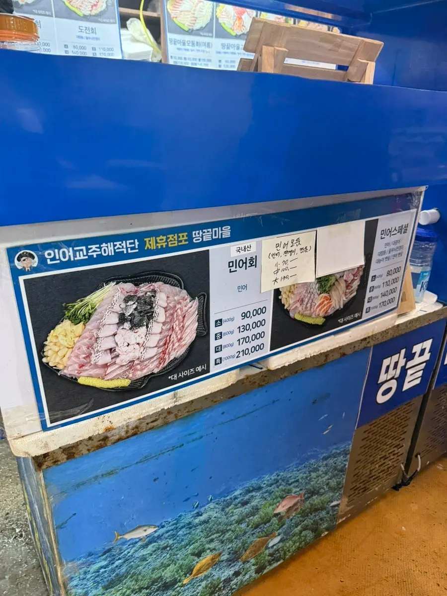 Ordering sashimi in front of the Ttangkkeut Maeul tanks