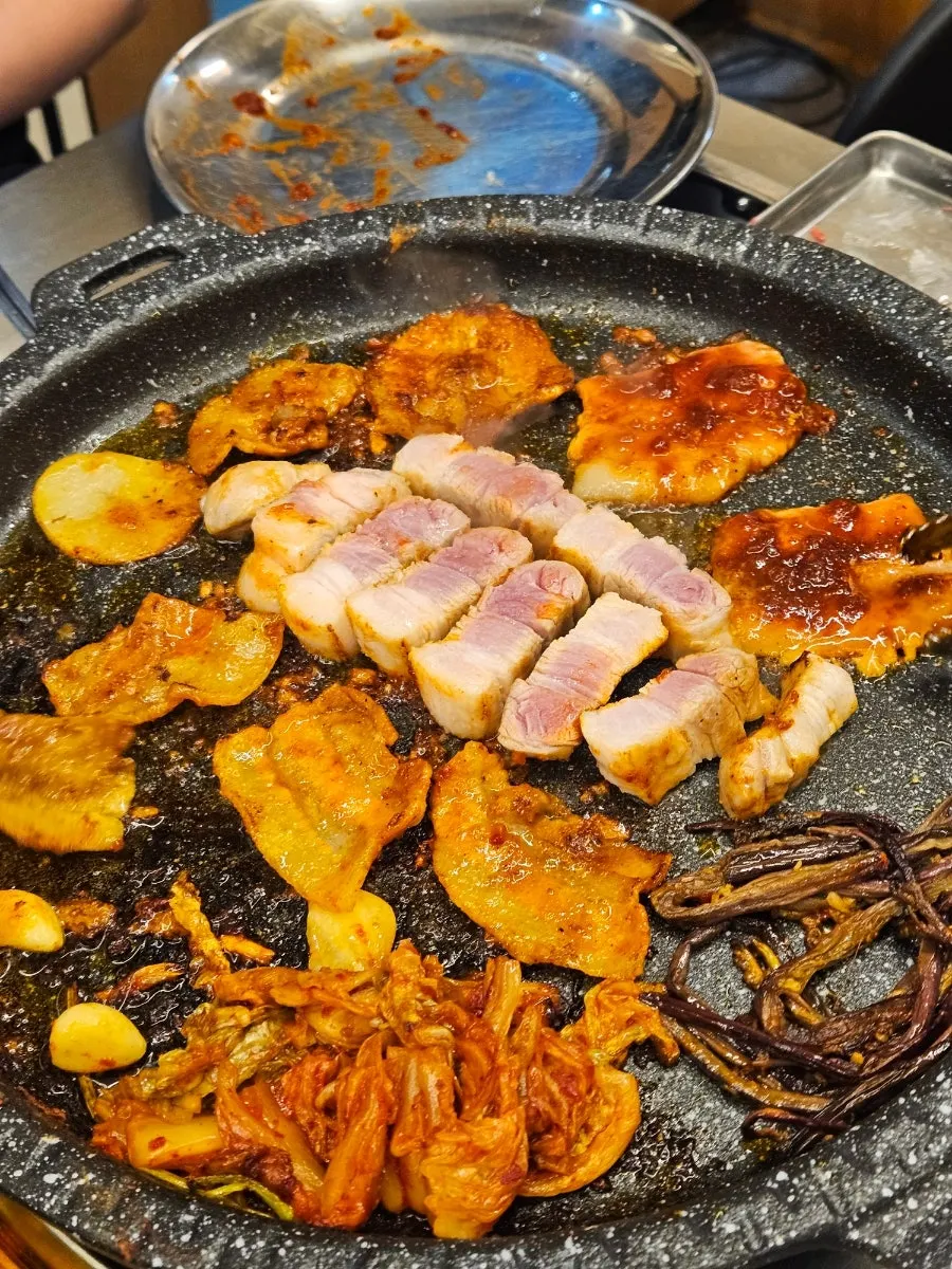 구운 김치와 고사리가 놓인 돌판 가장자리