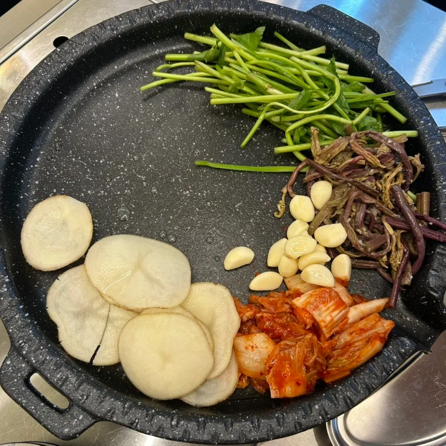 감자 김치 마늘 고사리 미나리가 놓인 불판 세팅