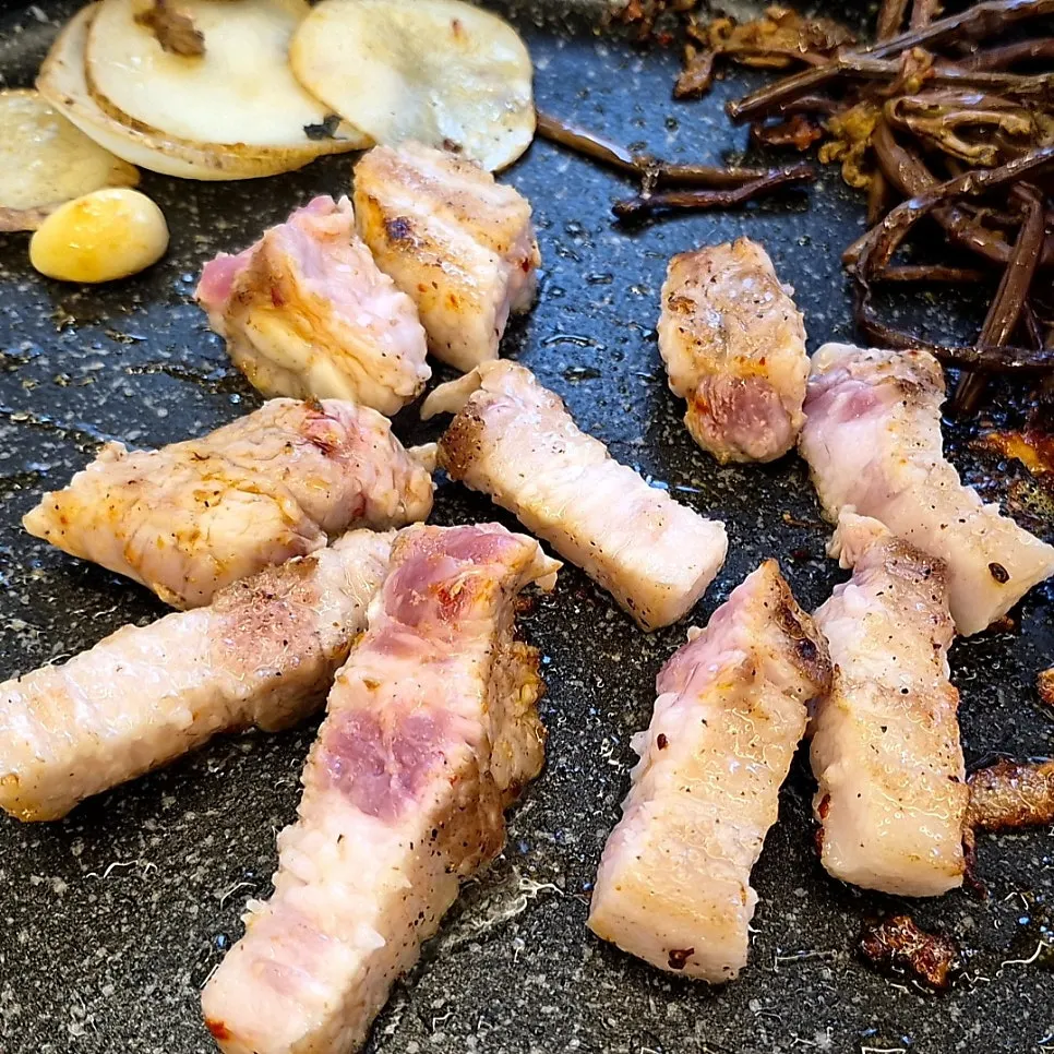 Korean pork belly cooking on the grill pan