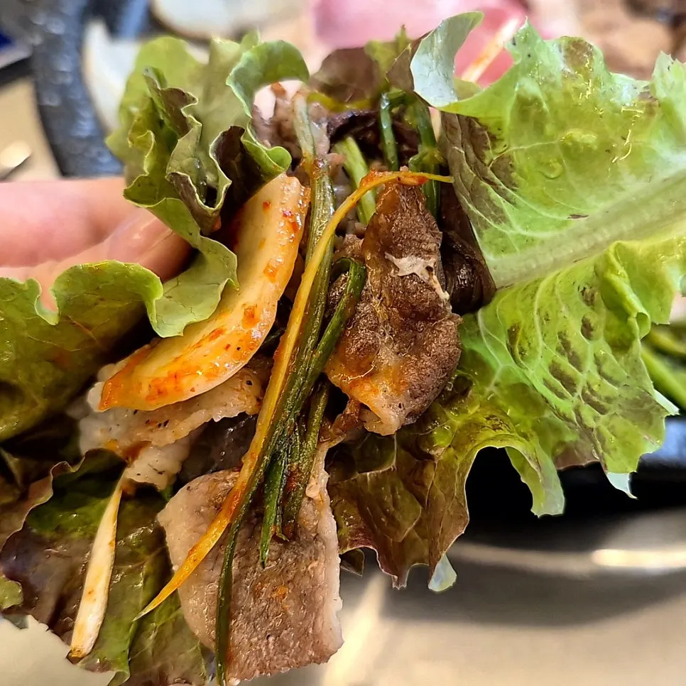 Pork belly with green onion salad in a lettuce wrap