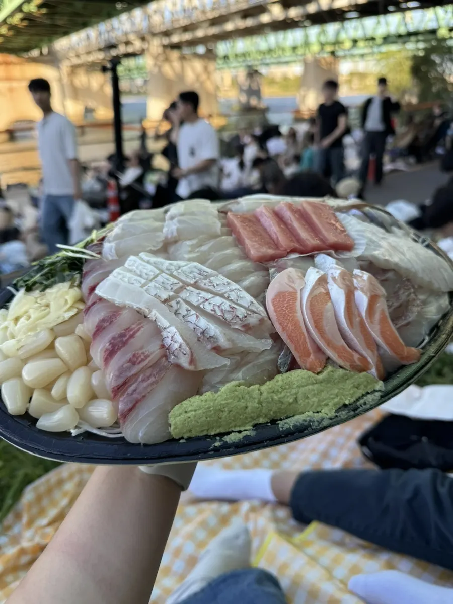 야외 돗자리에 펼친 모듬회와 곁들임