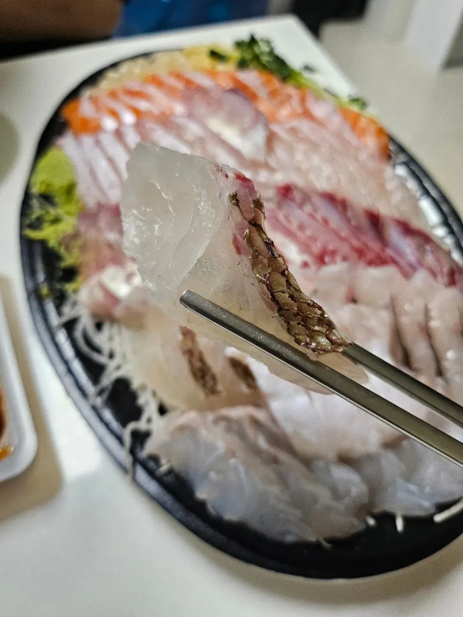 젓가락으로 집은 흰살회 한 점