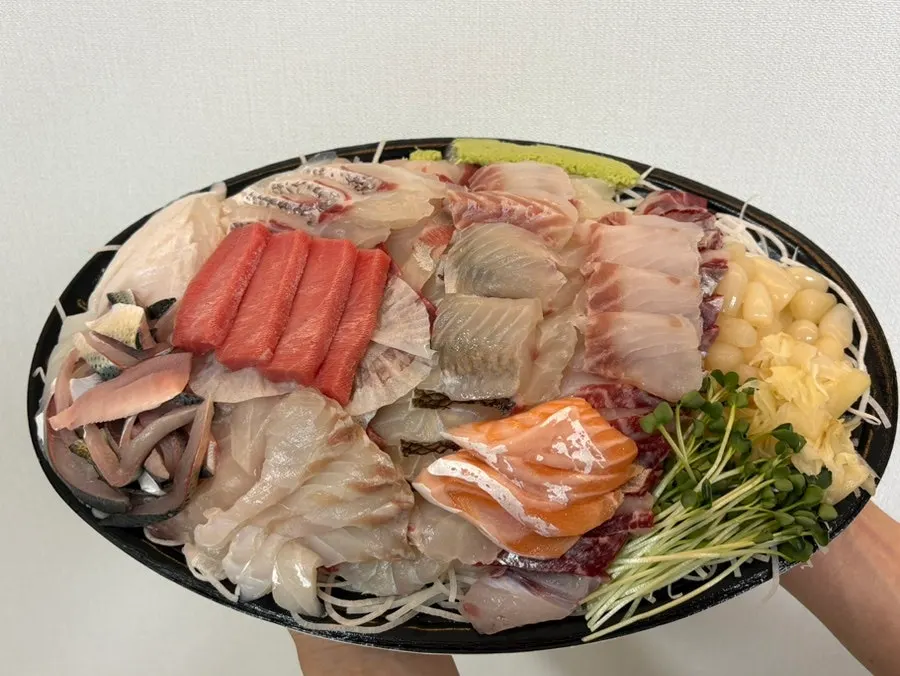 Sashimi packed in a takeout container from Ttangkkeut Maeul's premium platter