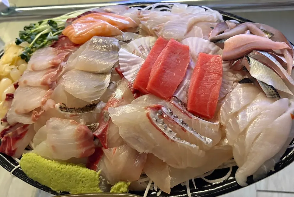 Ttangkkeut Maeul's premium sashimi platter stacked two layers deep