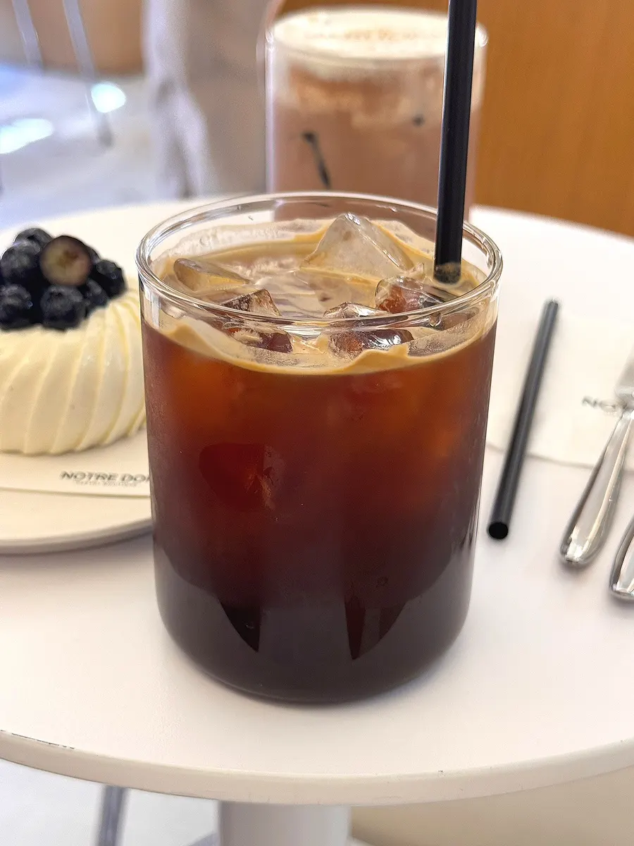 Iced americano served alongside dessert