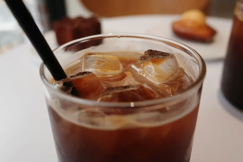 Two iced Americanos served alongside the desserts