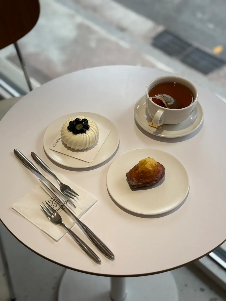 Mascaberry cake, lemon madeleine, and TWG French Earl Grey set on a table