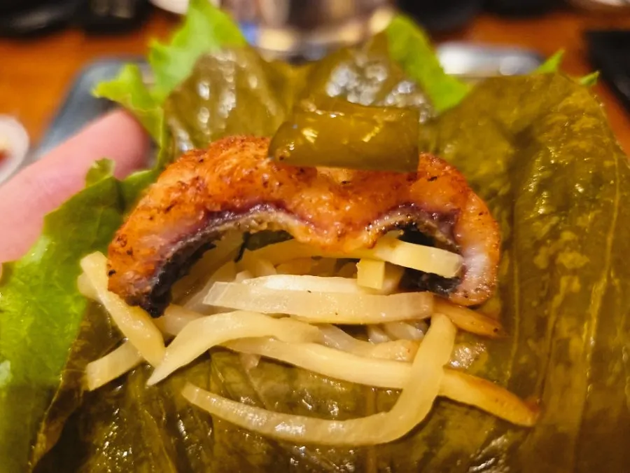 A piece of eel eaten with deodeok pickle