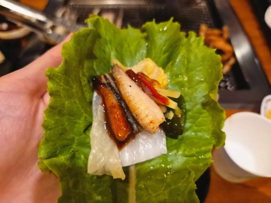A lettuce wrap with eel and deodeok pickle