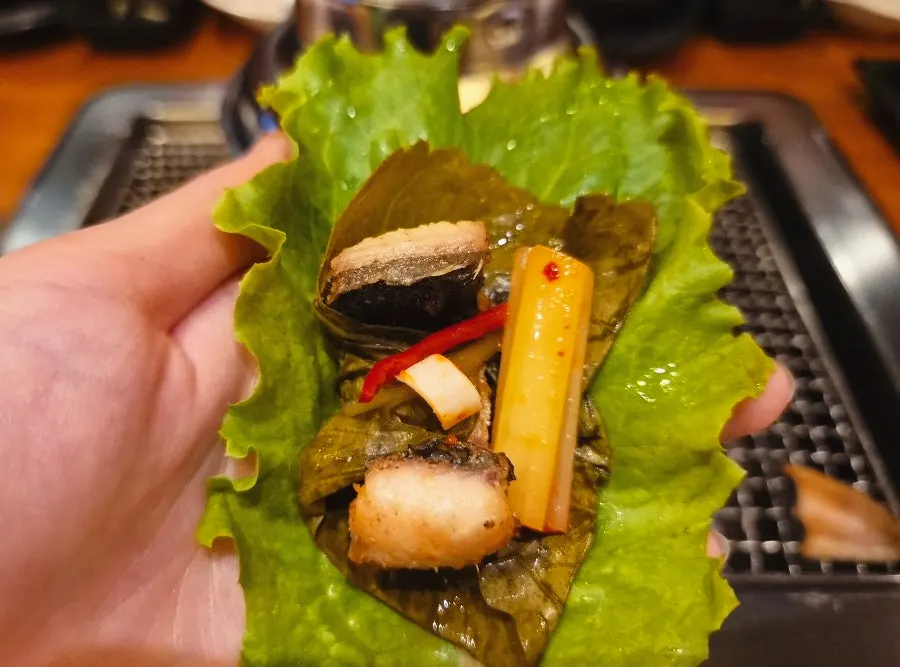 A perilla leaf wrap with eel and kimchi