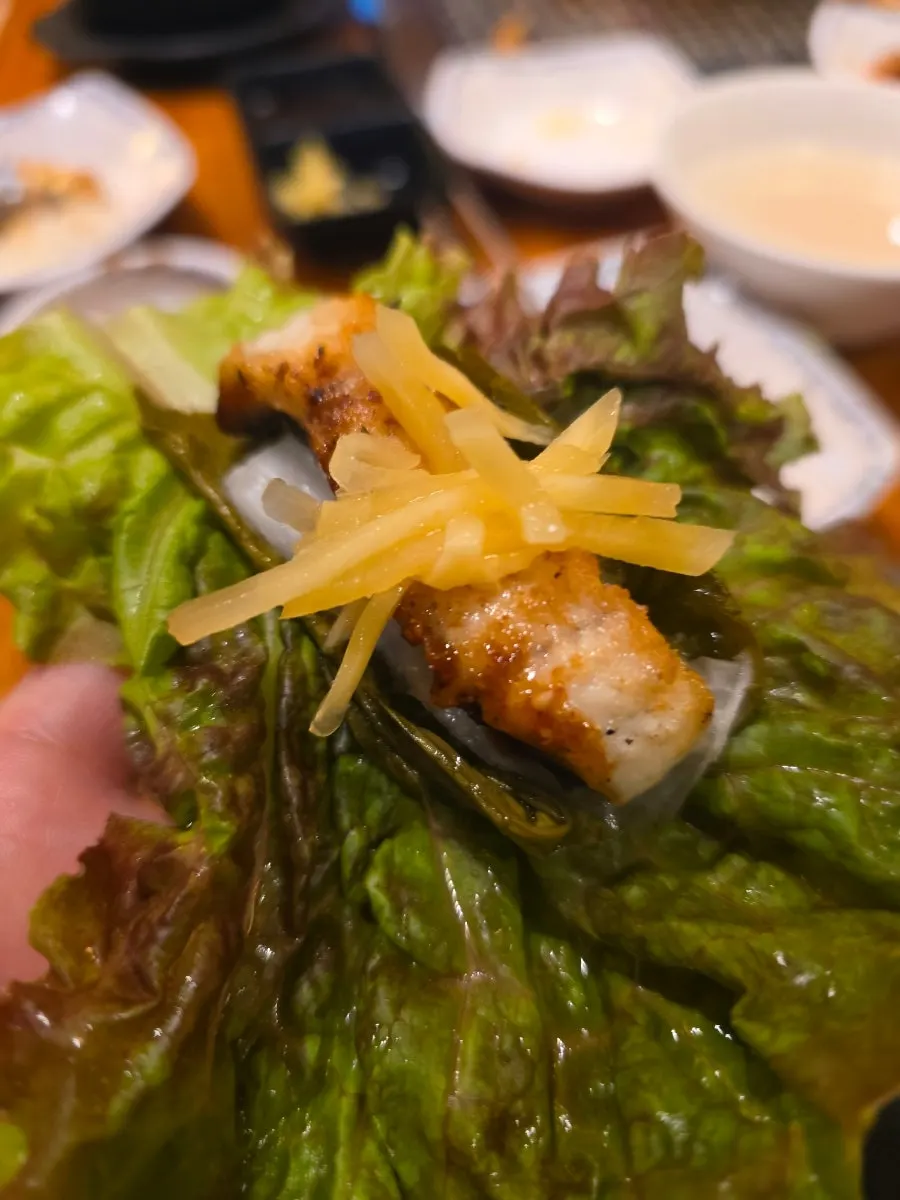 Lettuce wrap with eel, ginger strips, and white kimchi