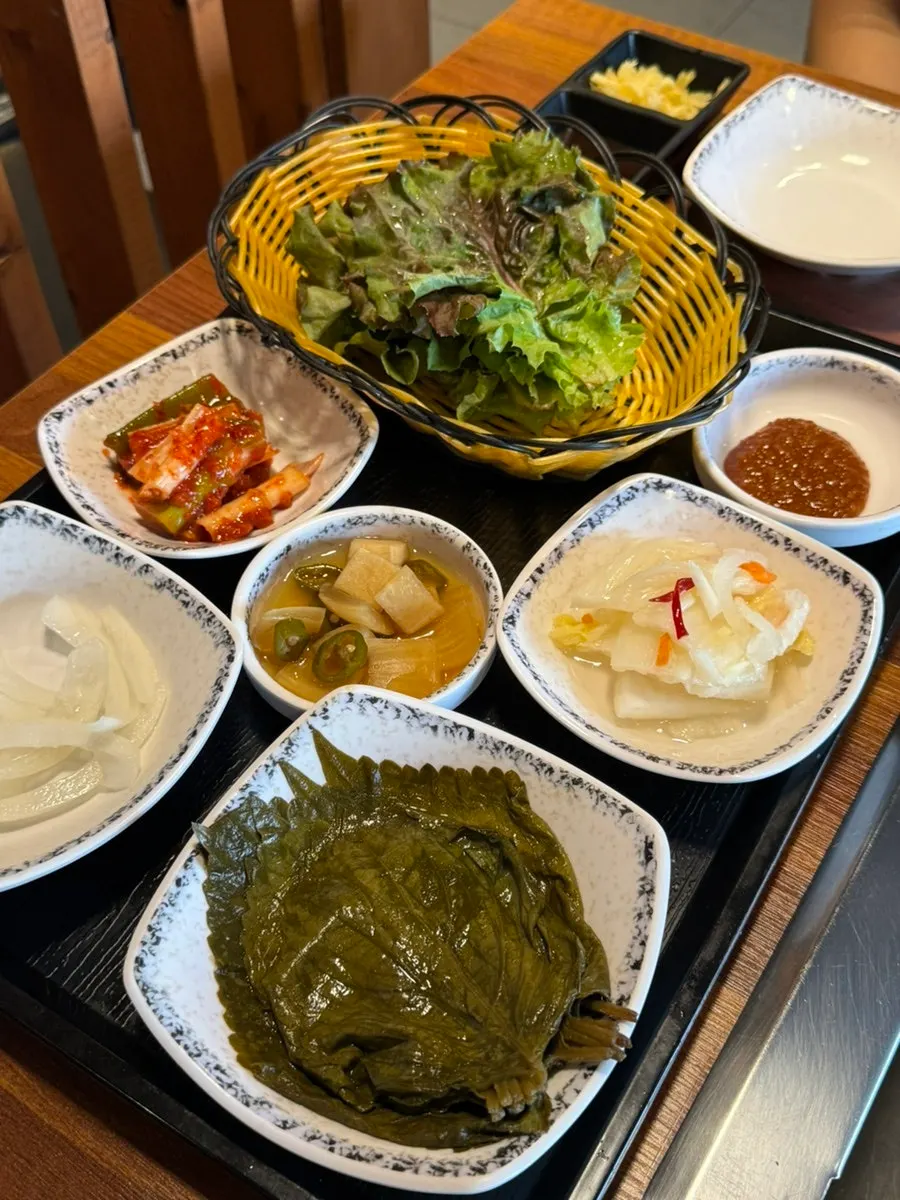 상추와 깻잎장아찌, 백김치가 포함된 밑반찬 한상