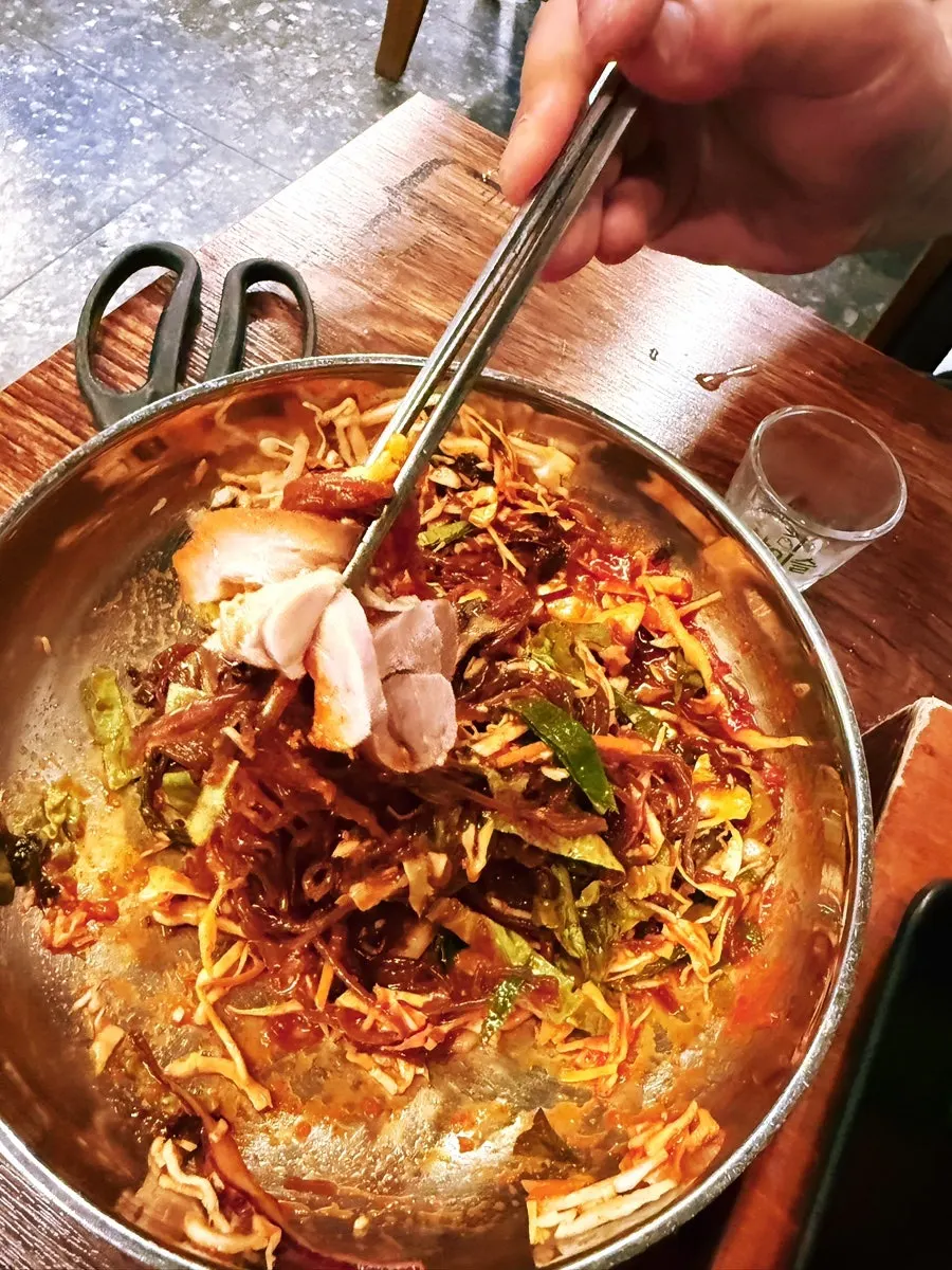 Makguksu topped with a piece of jokbal