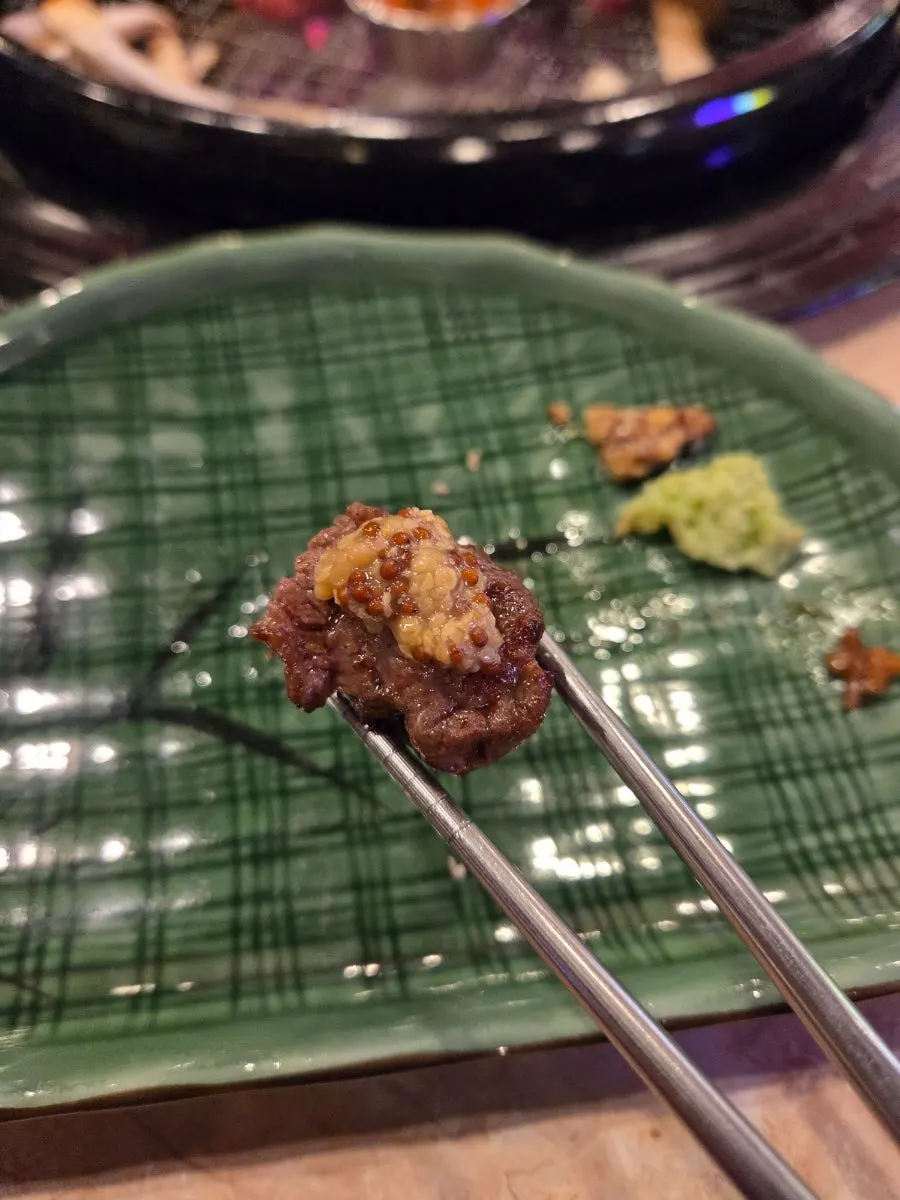 Beef short rib grilling to a golden brown over charcoal