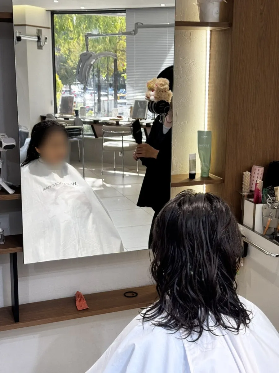 Child seated in the salon chair, ready for the treatment