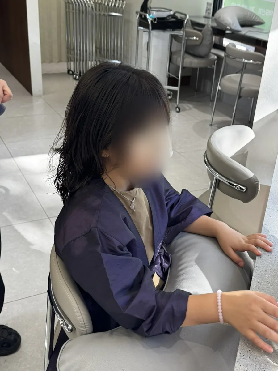 The child's hair ends looking calmer after the cut
