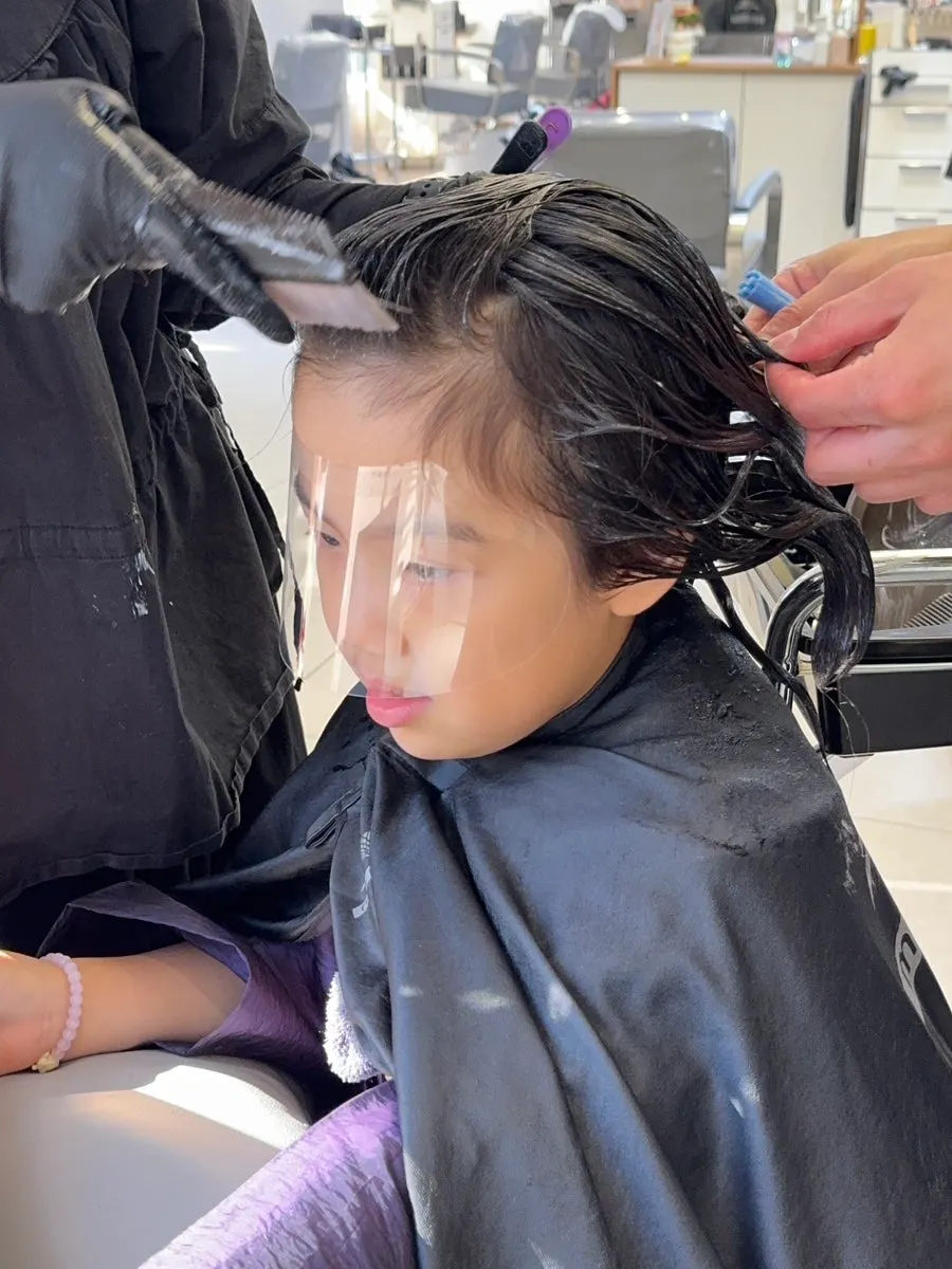 Perm solution being applied to the child's hair