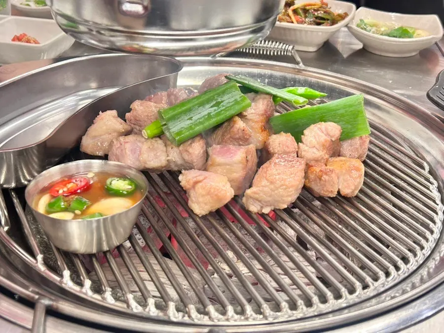 Pre-grilled pork collar on the charcoal grill