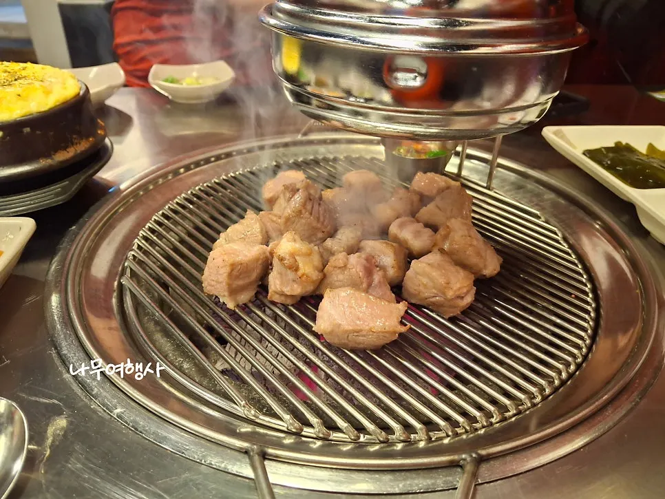 Pork neck placed on the grate to begin charcoal grilling