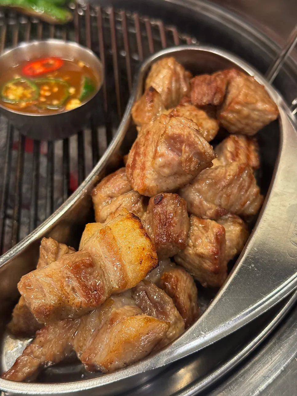 Thick pork neck grilled by a staff member