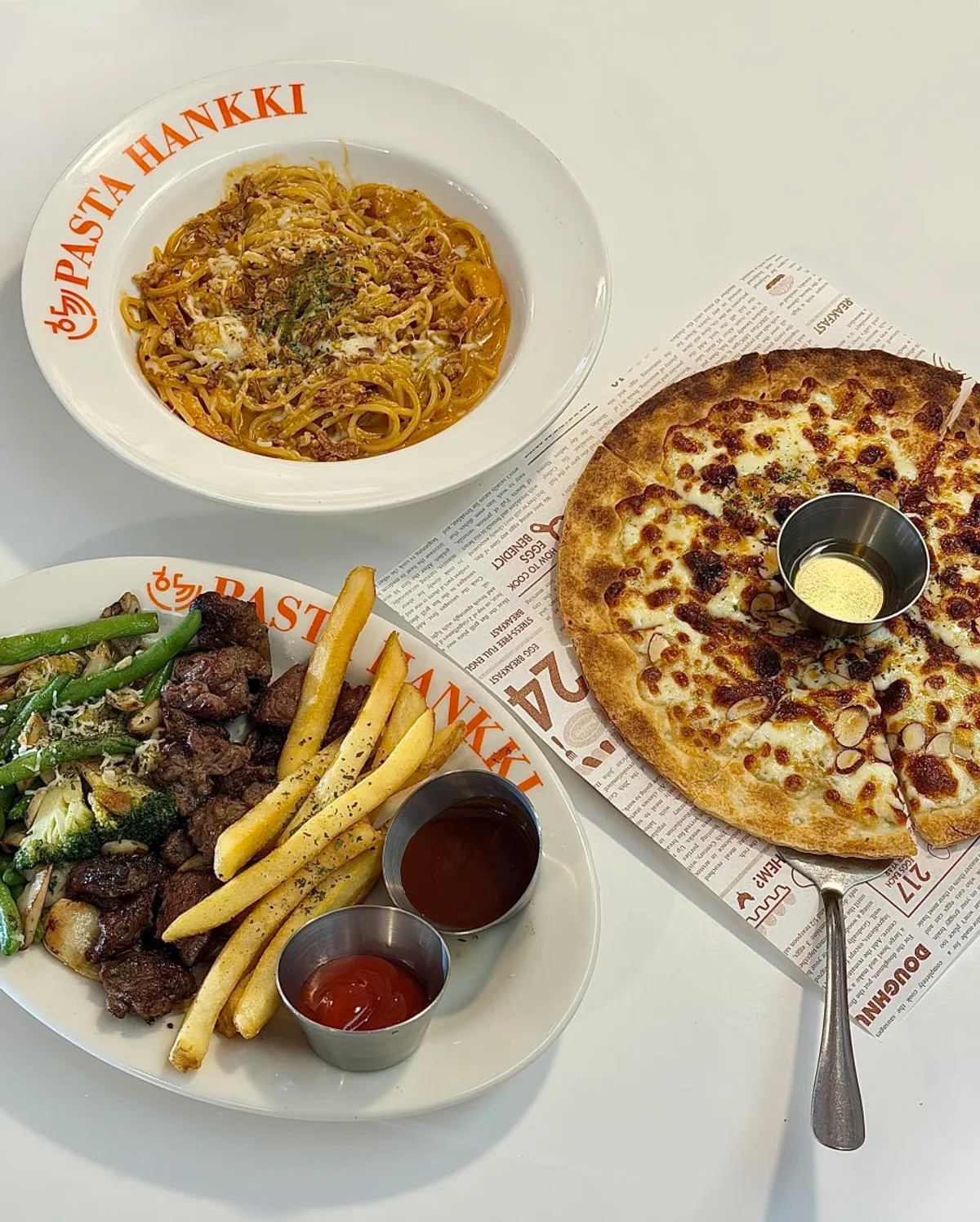 Table set with pasta, pizza and steak together