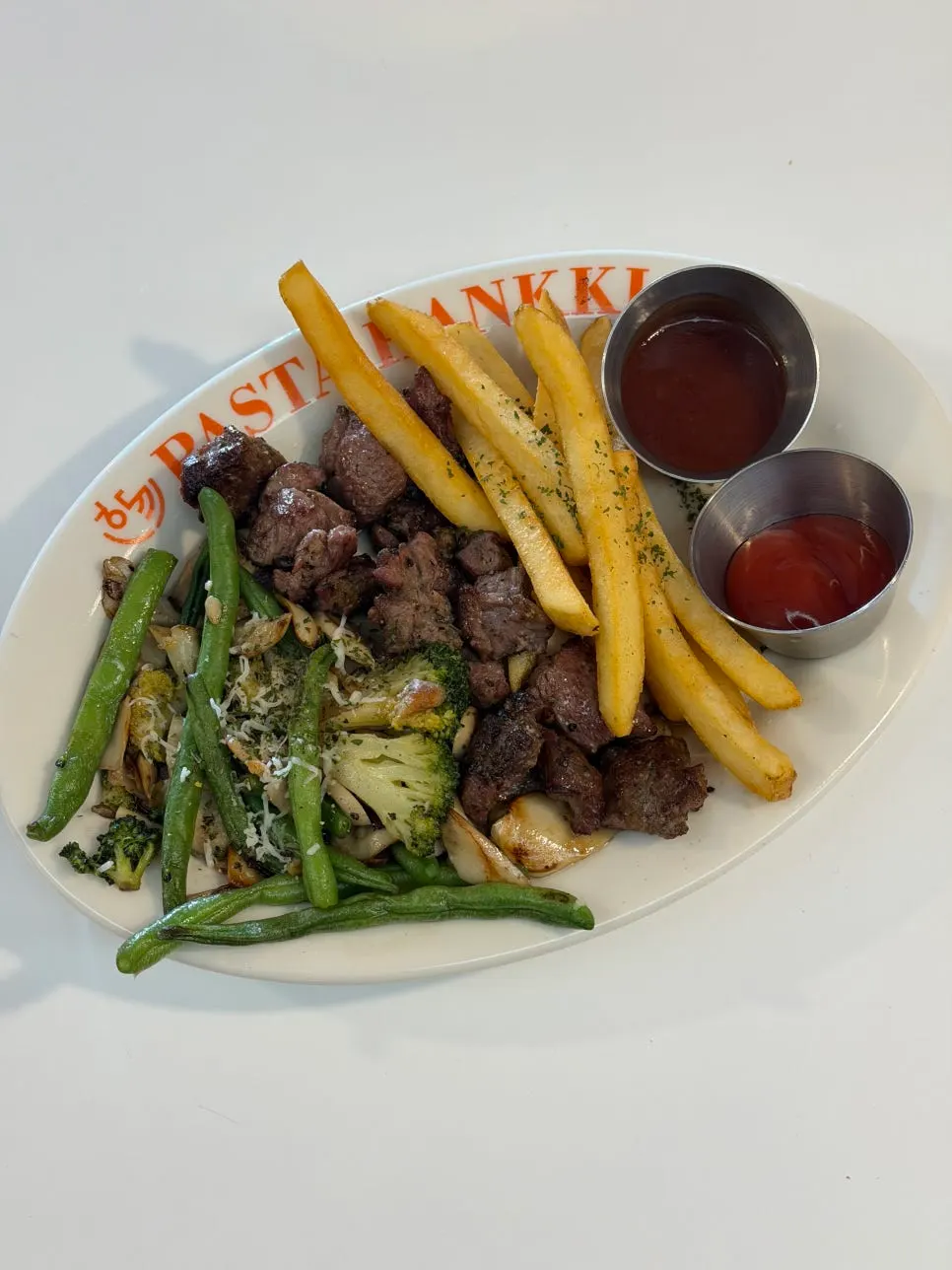 Plate of skirt steak with grilled vegetables and fries