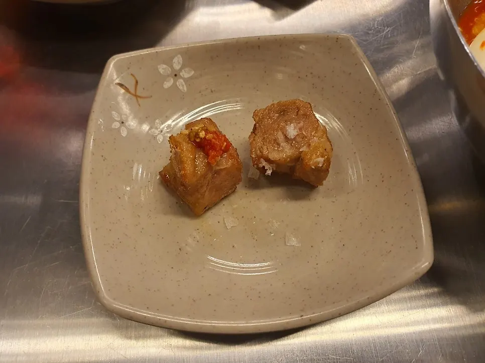 Grilled pork neck transferred onto a plate