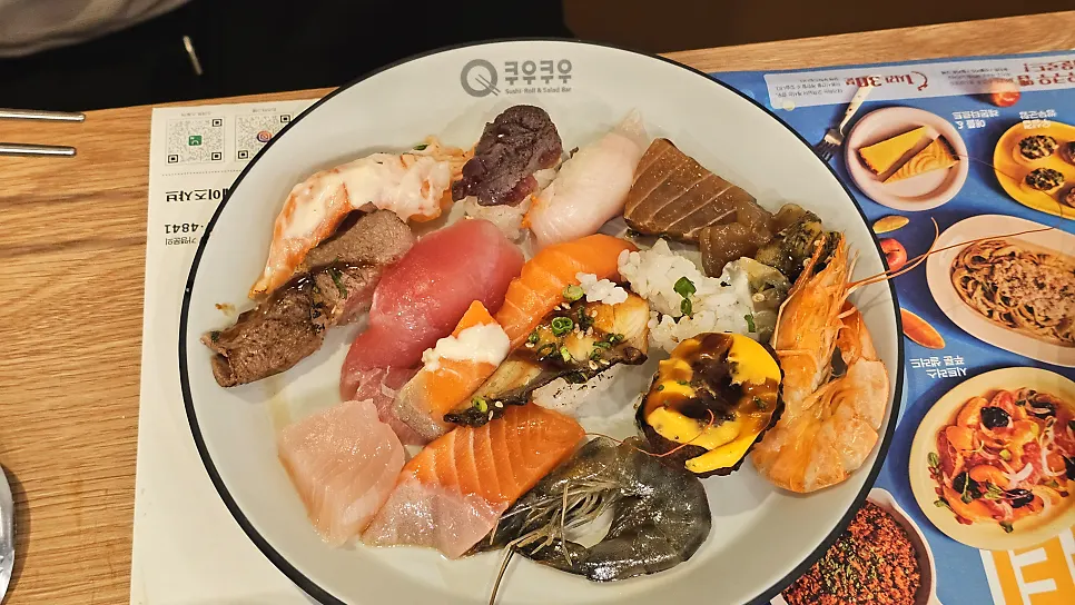 A plate of sushi and fresh salmon sashimi