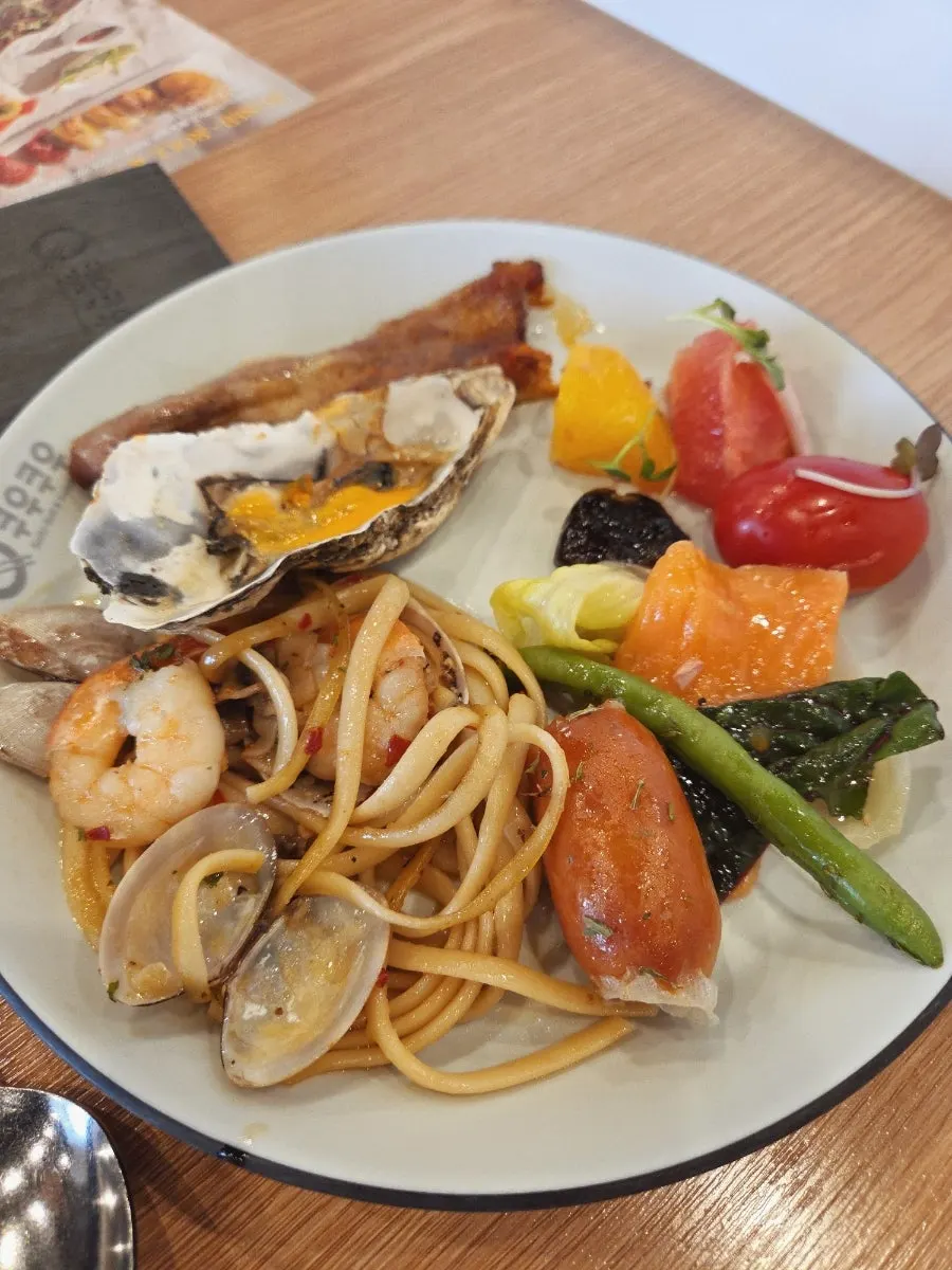 Plate of oil pasta, salad, and fruit