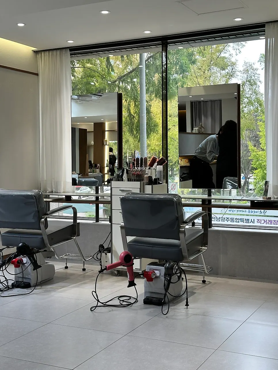 Salon interior with green trees visible outside the window