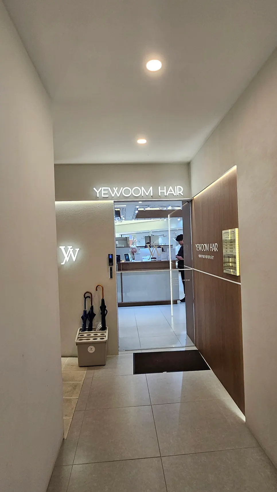 Tidy interior hallway of Yeum Hair in white and wood tones