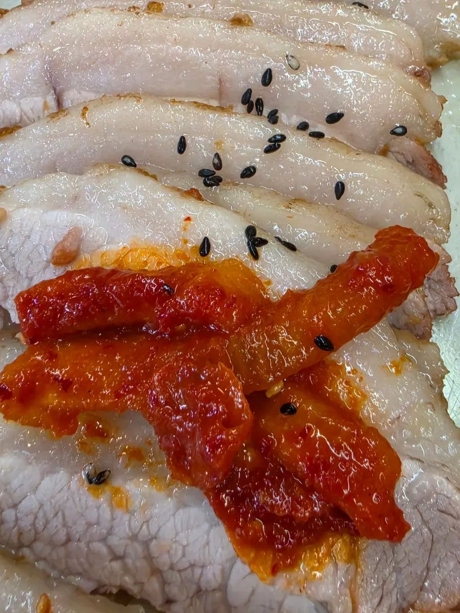 A piece of bossam meat topped with bossam kimchi