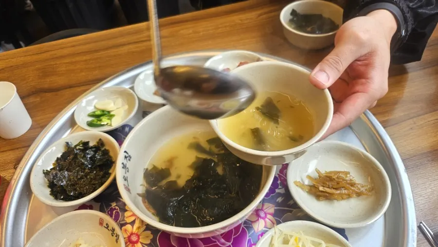 Side dish spread with bean sprouts, white kimchi, and seaweed flakes