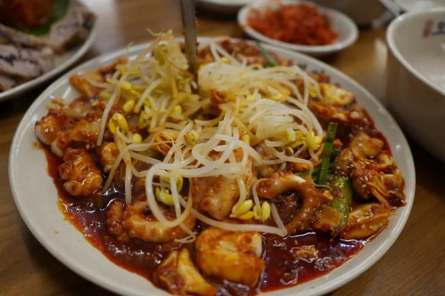 A piece of octopus stir-fry coated in sweet-spicy sauce