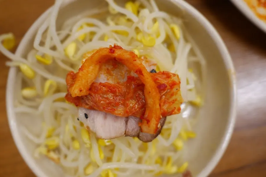A piece of bossam topped with dried radish strips