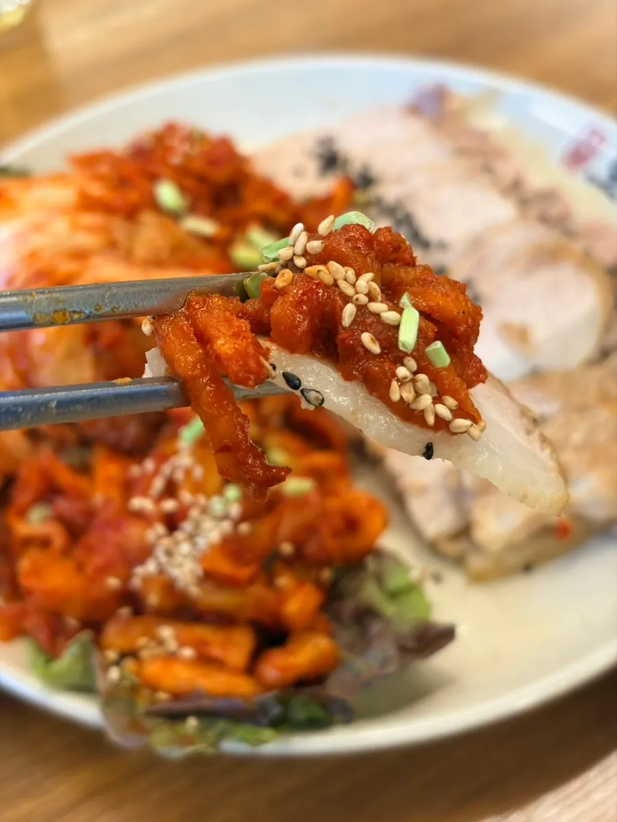 수육 한 점에 보쌈김치를 올린 모습