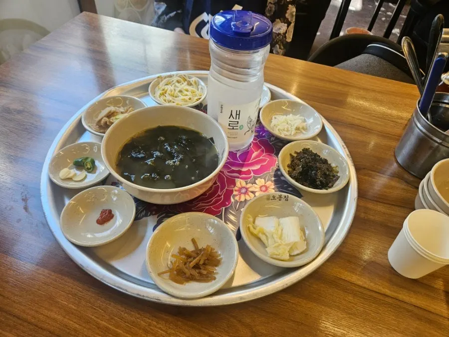 쟁반에 담겨 나온 밑반찬 여덟 접시와 미역국