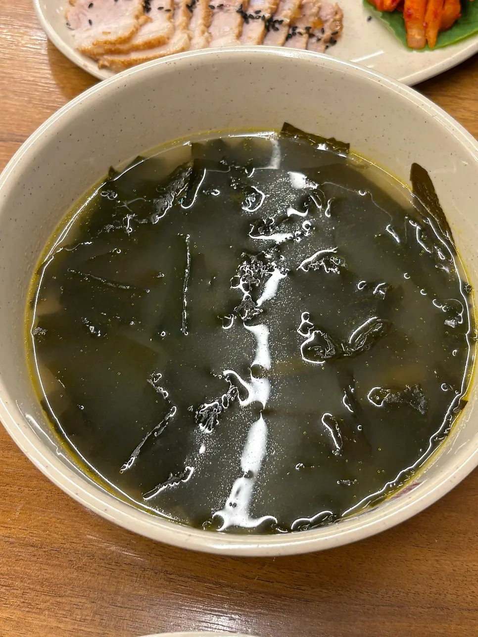 A bowl of seaweed soup with clams