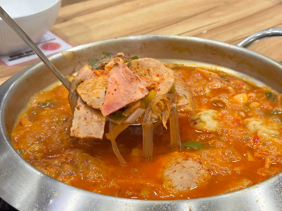 Flower Budae Jjigae topped with handmade ham and boiled dumplings