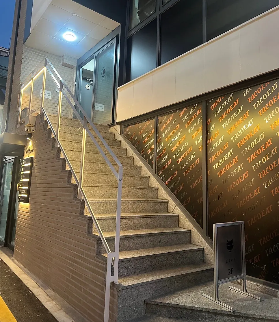 Lit staircase leading up to Ochaya on the 2nd floor