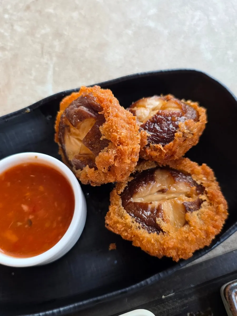 Shiitake tempura on a black plate