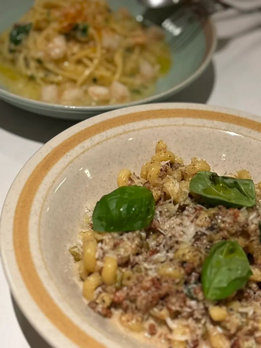 Two plates of pasta set on the table