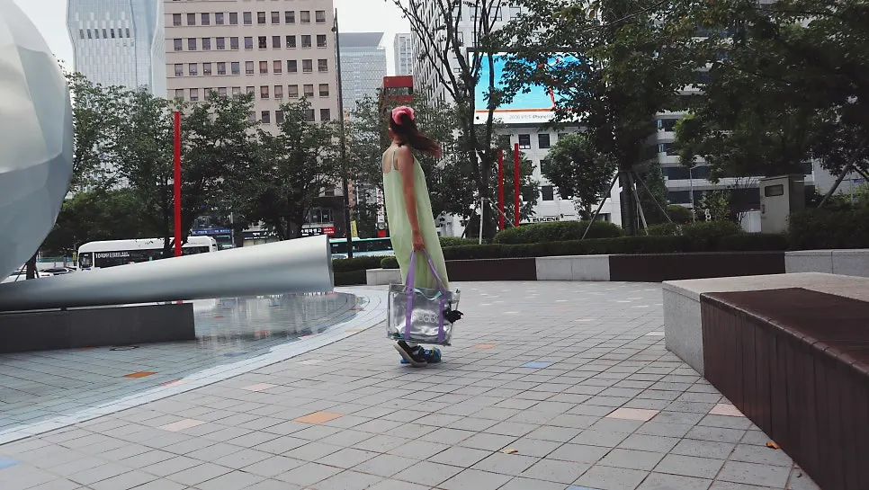 Transparent beach bag worn with a sleeveless outfit
