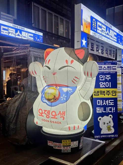 가게 입구의 작은 벚꽃나무와 커다란 고양이 장식