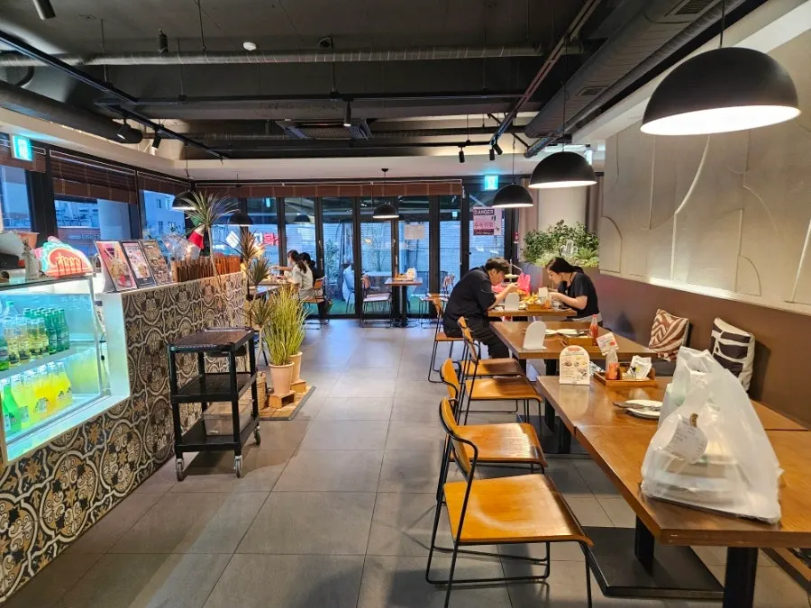 Restaurant seating with four-person tables and a long communal table