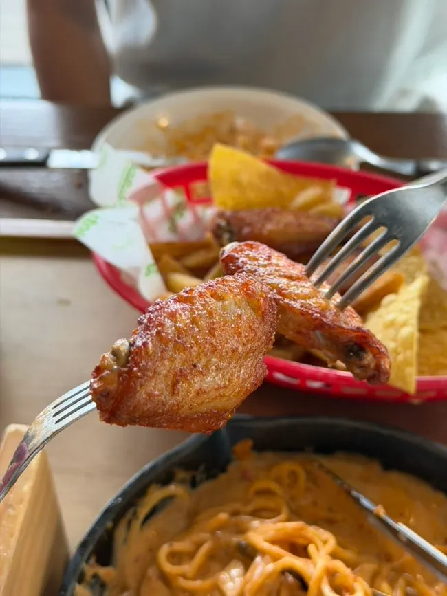 A diner holding a Buffalo wing