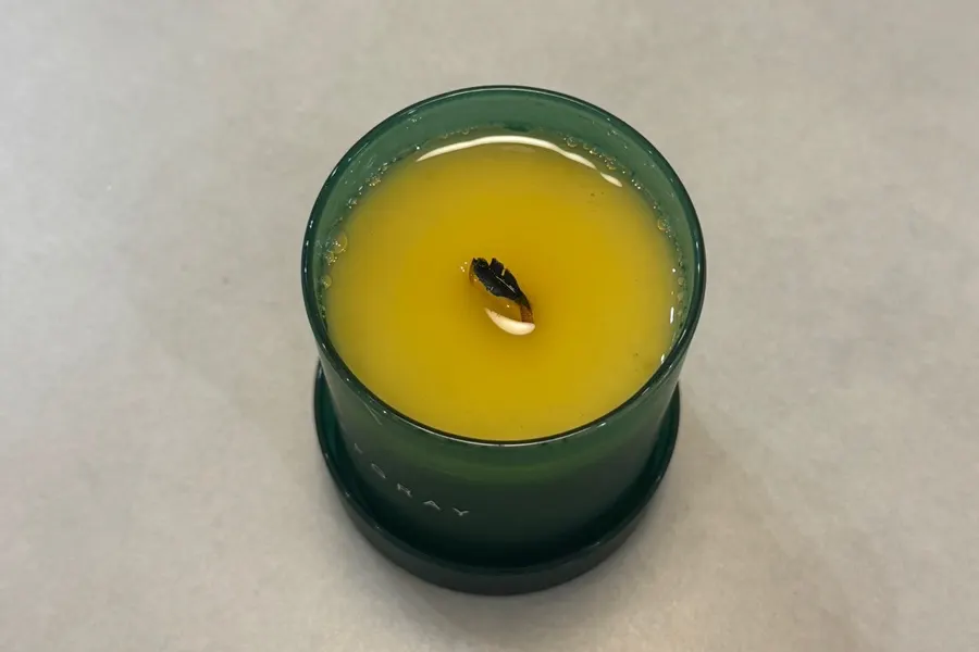 Melted Offgray soy wax and wood wick after burning