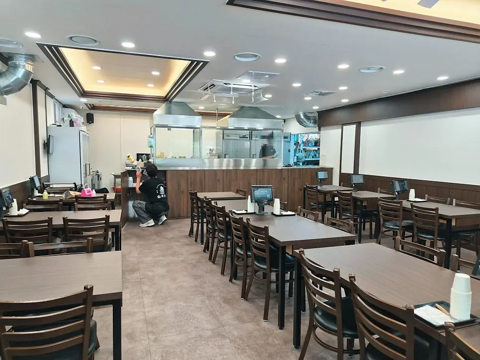 植木鉢と木製ベンチが置かれた店の入口